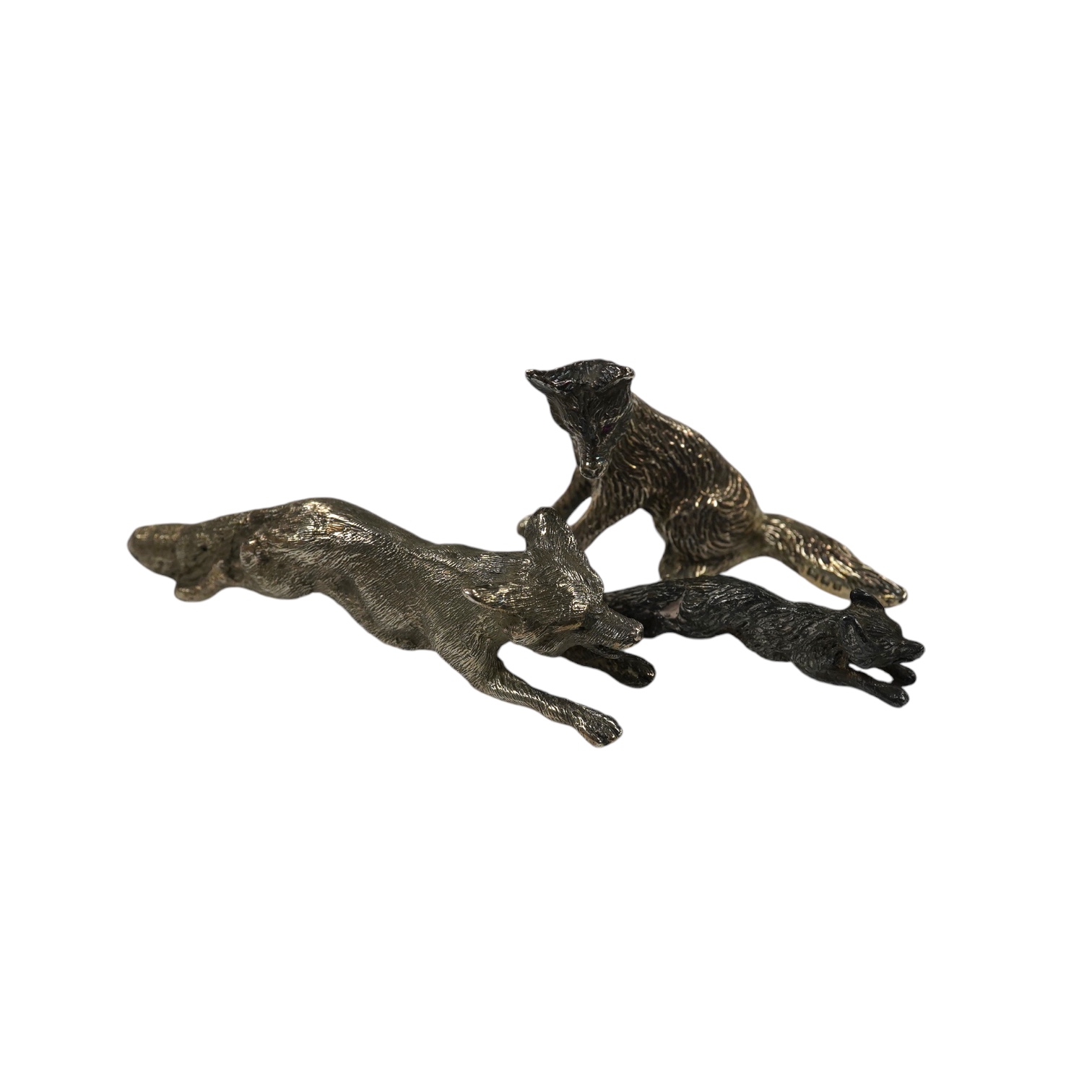 Two 1960's silver miniature models of a fox, both London, 1968, seated by Edward Barnard & Sons Ltd, height 38mm and one other smaller silver model of a running fox, 6.7oz. Condition - fair to good